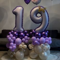 stacked number balloon arrangement with purple & gold accents. 