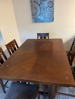 Brown expandable dinning table for 6 to 8 people with 6 chairs.