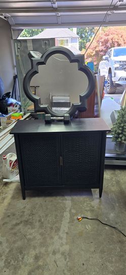 Black rattan cabinet with black quatrefoil mirror