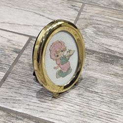 Precious Moments cross stitch embroidery in solid brass frame with glass