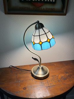 Tiffany-style stained glass table lamp with a white, blue, and yellow geometric shade.