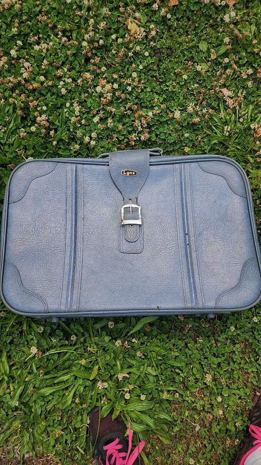 Large soft shell blue suitcase by Lynx. Measures 24" W x 16" H x 7" D. Some Rust On the decorative strap in front, otherwise pretty good.