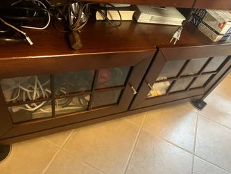 Brown like new TV stand with glass doors