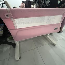 Evenflo pink portable bassinet or bedside sleeper, which is a common type of baby furniture designed for infants to sleep close to their parents.
