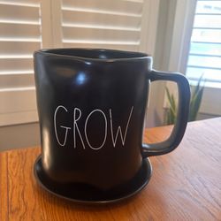 $25 - Rae Dunn large ceramic mug planter "Grow" with attached drip plate. Color - Black. Measures 8.5” tall x 6.5” diameter. Please pick up within