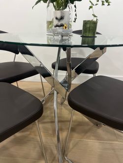 Modern dinette set.  4 Modloft faux leather chairs + round glass and chrome table