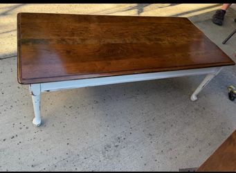 distressed two-tone rectangular wooden coffee table with a warm amber-stained top and a white-painte