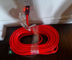 New high-visibility orange 100ft heavy-duty cord with lighted ends (likely the female end glows when powered, a common safety feature to confirm it’s 