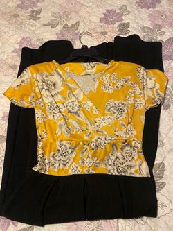 vibrant yellow short-sleeve V-neck wrap top with a white floral print, paired with a black pleated dress