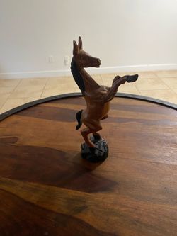 A vintage hand-carved wooden sculpture of a rearing horse.