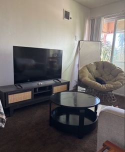living room set up ; tv, tv console, papasan chair, table and couch