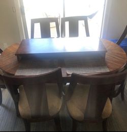 Dining Set Components: Includes an oval table and four matching chairs with table leaf.