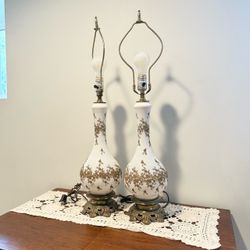 vintage pair of mid-century or Hollywood Regency-style milk glass or opal glass table lamps featuring a white frosted finish with raised metallic gold