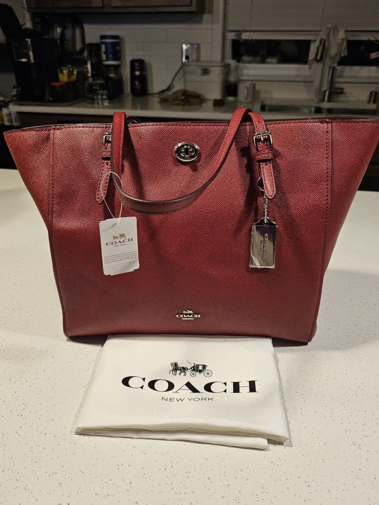 COACH burgundy leather tope with silver hardware.