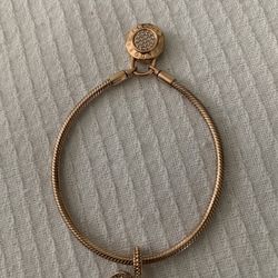 Rose gold-plated Pandora snake chain bracelet with padlock clasp and heart charm.