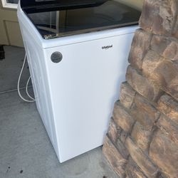 Whirlpool top-load washing machine with a glass lid and digital control panel