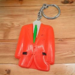 Vintage Men's Orange Suit Keychain, spot of green paint on back
