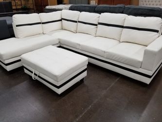 Contemporary white faux leather sectional with a matching storage ottoman