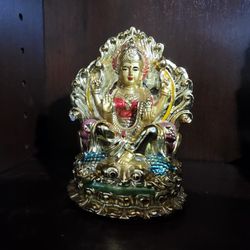 Intricately designed gold-colored Hindu Goddess Lakshmi figurine with vibrant details.