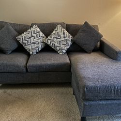 Living Spaces Dark grey sofa with reversible chaise & 4 cushions