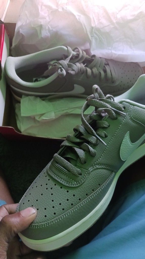 A low-top sneaker with a grey/olive leather upper and a gum/cream sole.