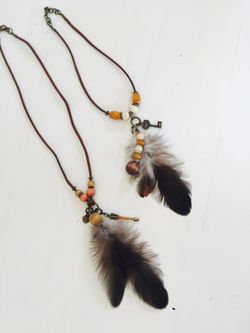 Hand made feather and charm necklaces.