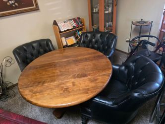 Circular wood table with 4 rolling leather chairs