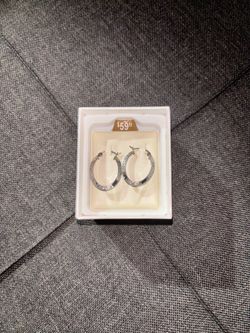 Silver hoop earrings with textured surface