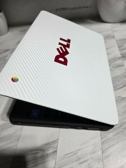 Dell Chromebook with a white carbon fiber skin applied to the lid and a Chrome OS logo badge. Black base with an Intel sticker visible. Good used cond