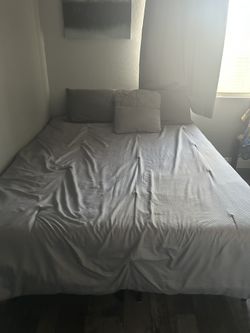 Full size mattress with covers, pillows, and bed frame