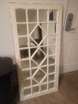 white windowpane-style decorative wall mirror with a geometric trellis frame.