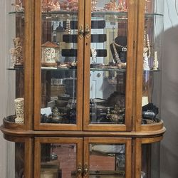 Cabinet 4 door oak curio with beveled glass and lighting by Pulaski Furniture ( Very Good Condition )