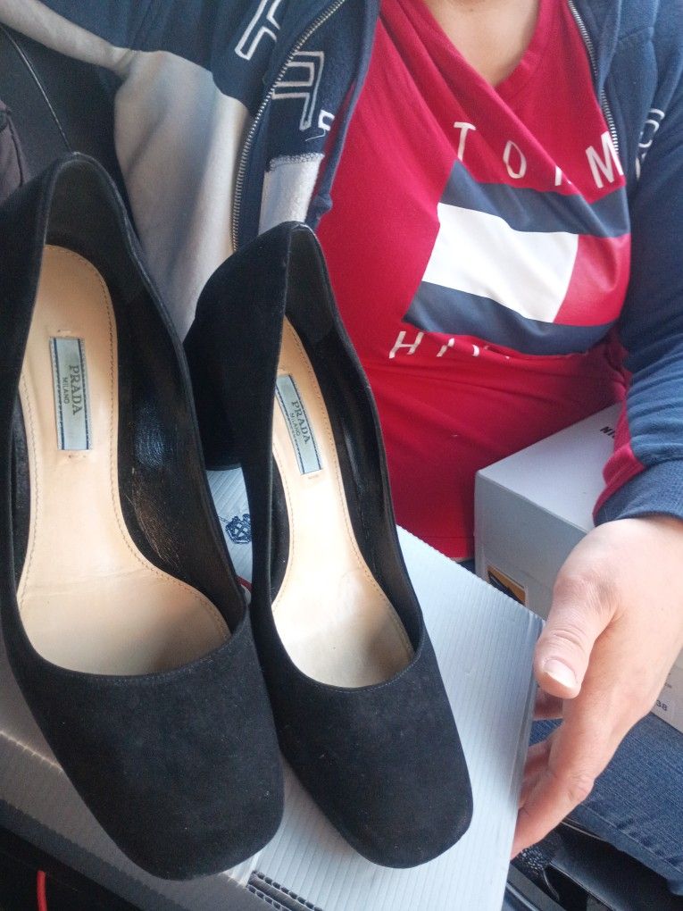 This is a pair of black suede Prada block heel pumps.