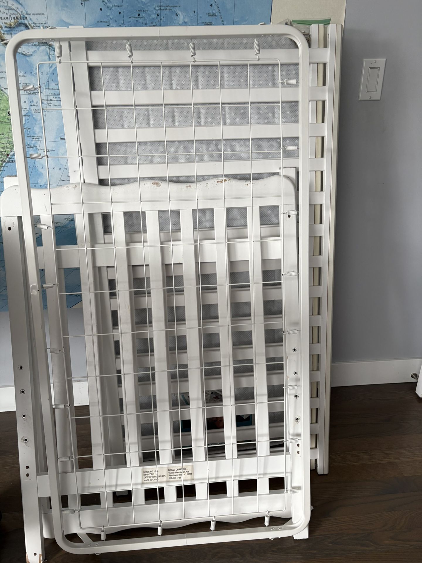 White baby crib with a mattress