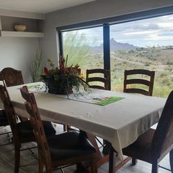 Very large wooden dining room table with eight chairs