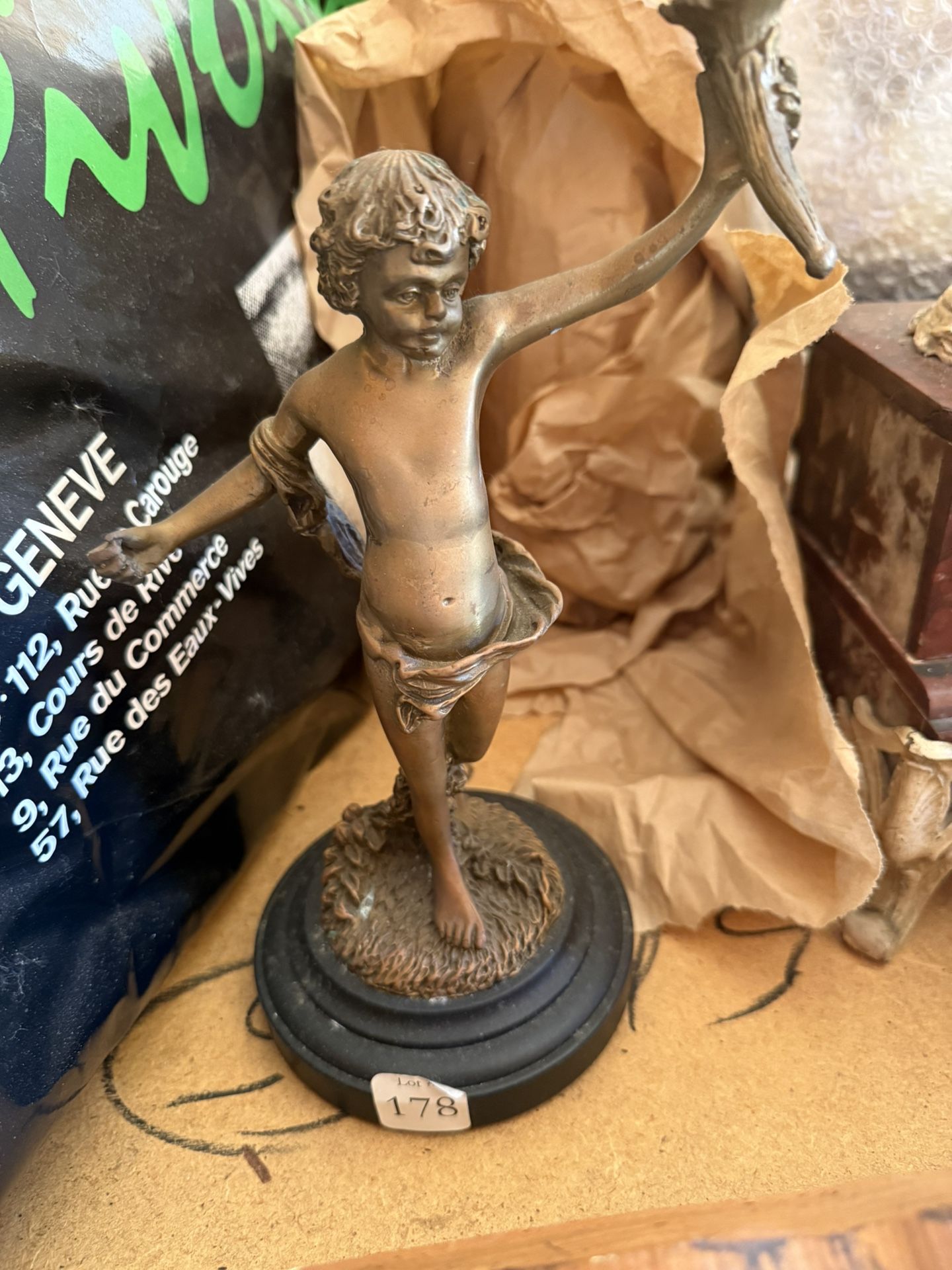 bronze sculpture depicting a young boy, possibly a cherub