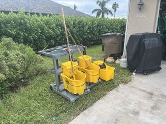 Three Mopping Buckets And Two Janitors Carts.