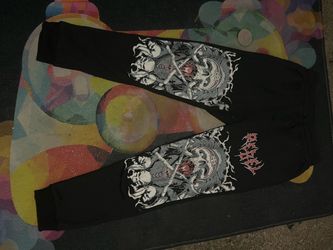 Unisex heavy metal/gothic "Rebel" script font alongside an intricate dual-skull illustration reminiscent of biker and alternative streetwear