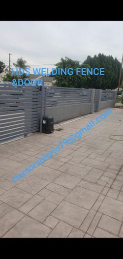 A sliding door with its motor and its fences and a small entrance door.