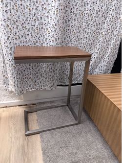 C-table with brown table top. Stainless steel legs