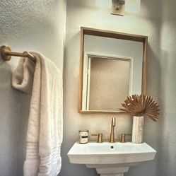 Gold Faucet Bathroom With A Matching Mirror