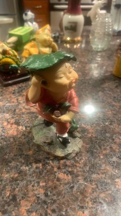Rare statue Asian boy leaf over his head blowing kiss in the rain