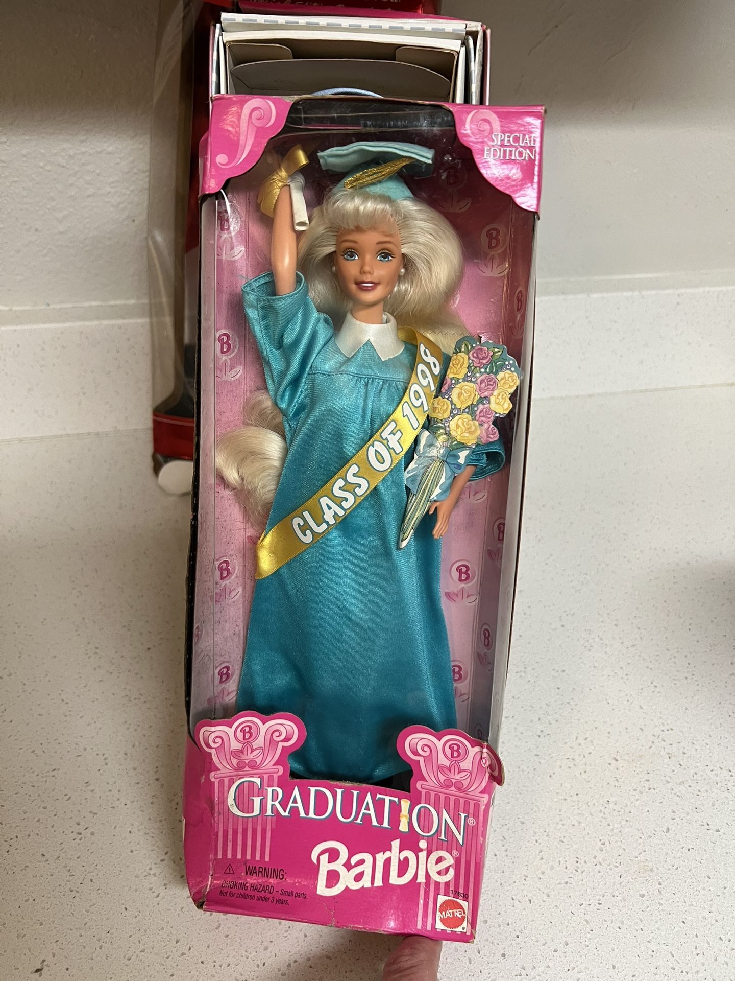 Mattel Special Edition Class of 1998 Graduation Barbie doll, product number 17830. The doll wears a teal blue graduation cap and gown with a gold "CL