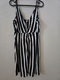 Sleeveless tie-front dress with bold vertical black and white stripes. Deep V neckline, relaxed  Lightweight, versatile piece for day or night styling