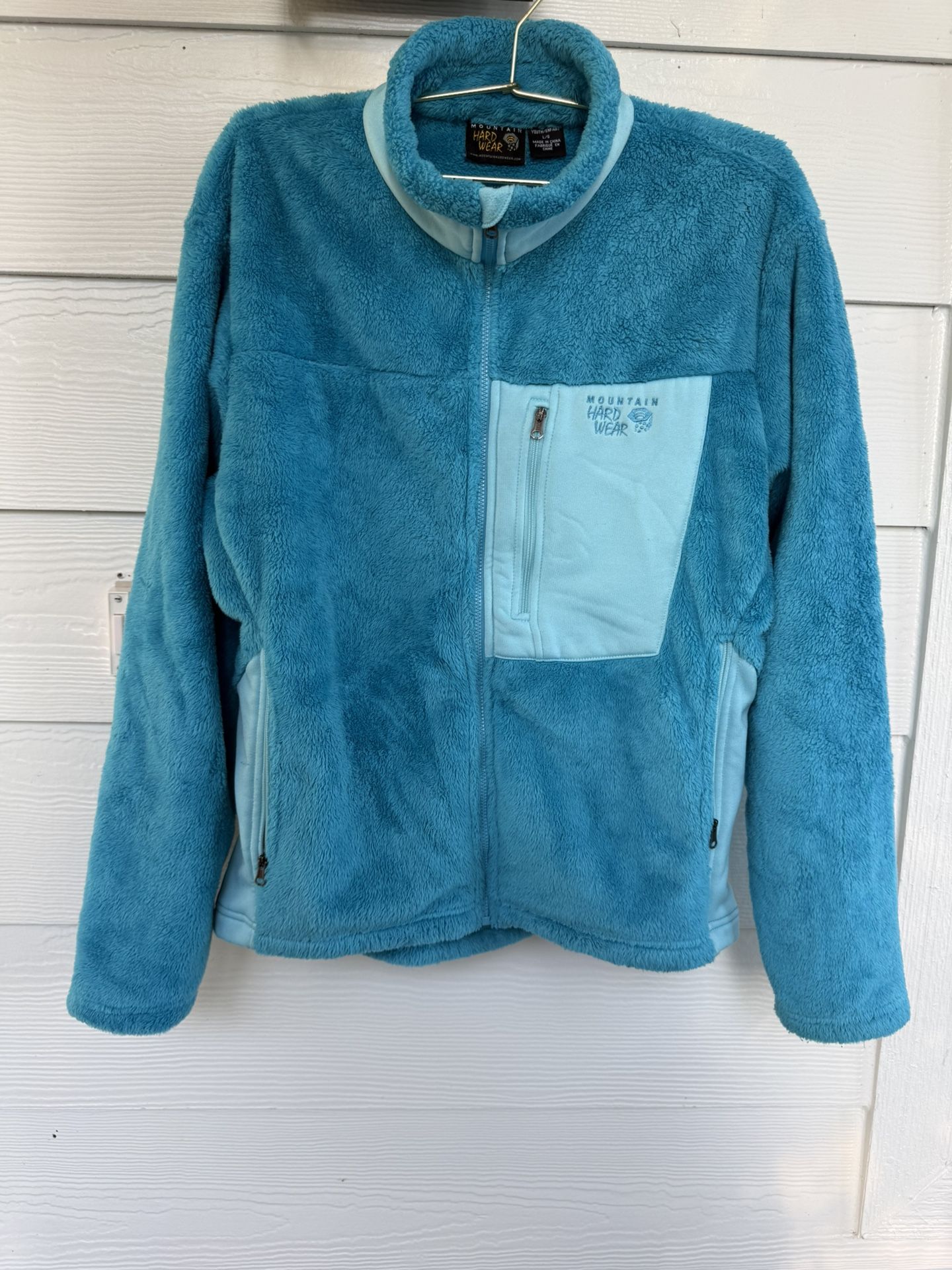 Mountain Hardwear fleece jacket in bright turquoise with lighter aqua accents. Full-zip front, zippered side pockets, and one chest pocket. Warm, soft