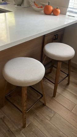2 swivel barstools with white fabric seats