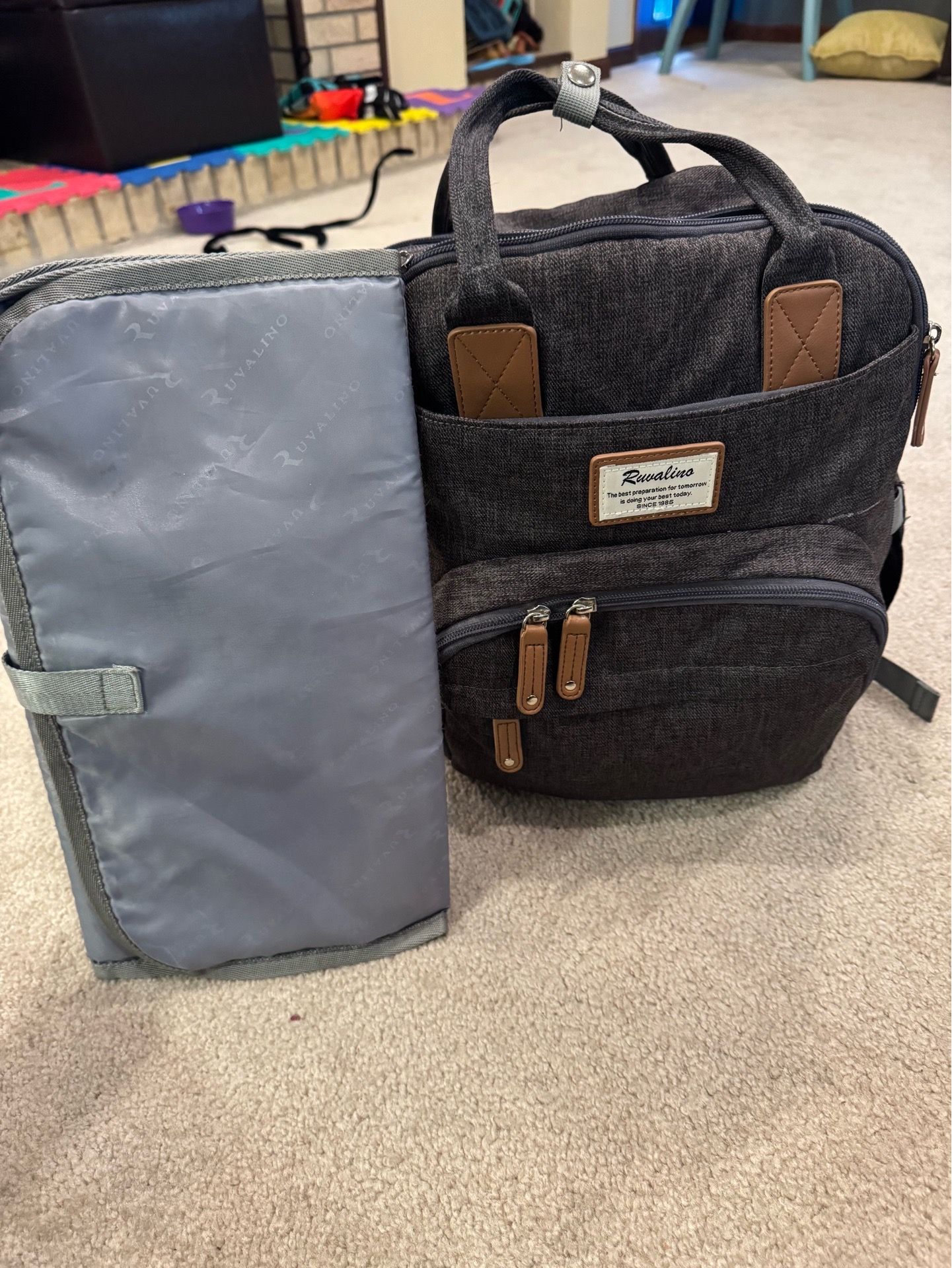 Gray diaper bag with changing mat.