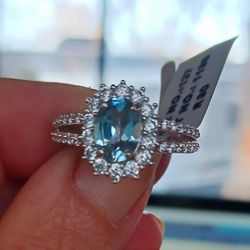Stunning Blue Topaz Total 2.7 cts, Adorned With Halo Style Cubic Zirconia Stones Surrounding The Topaz And Running Down Both Sides. 925 Silver Size 6