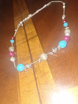  beaded necklace with turquoise, reddish-brown, and silver-tone beads on a silver-tone chain. 