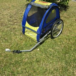 blue and yellow Schwinn child bike trailer